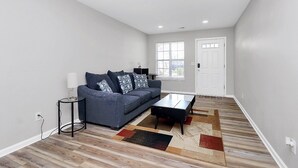 A modern living room with a sofa, coffee table, and a rug.