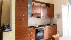 Una cocina con armarios de madera, una estufa y un lavamanos.