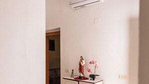 Una habitación con un armario blanco, un equipo de aire acondicionado y una pequeña estatua encima.