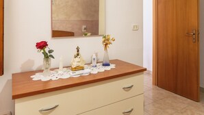 Un baño con tocador de madera, un espejo y una puerta.