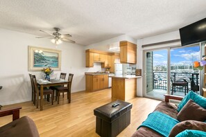 Eine moderne Wohnung mit Essbereich, Küche, Wohnzimmer und einem Balkon mit Stadtblick.