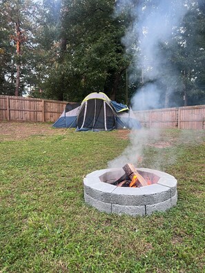 A fire pit with a tent in the background. - Atlanta Oasis with a Spa Suite, Huge Backyard, Fire Pit & Hammocks (Atlanta)