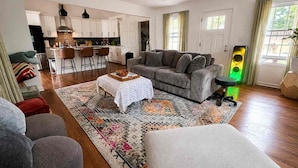 A modern living room with a sofa, ottoman, coffee table, and a patterned rug. - Atlanta Oasis with a Spa Suite, Huge Backyard, Fire Pit & Hammocks (Atlanta)