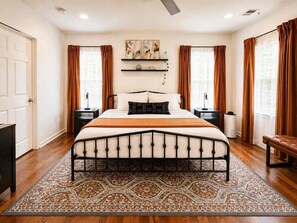 A bedroom with a bed, nightstands, a bench, a radiator, and a patterned rug. - Atlanta Oasis with a Spa Suite, Huge Backyard, Fire Pit & Hammocks (Atlanta)