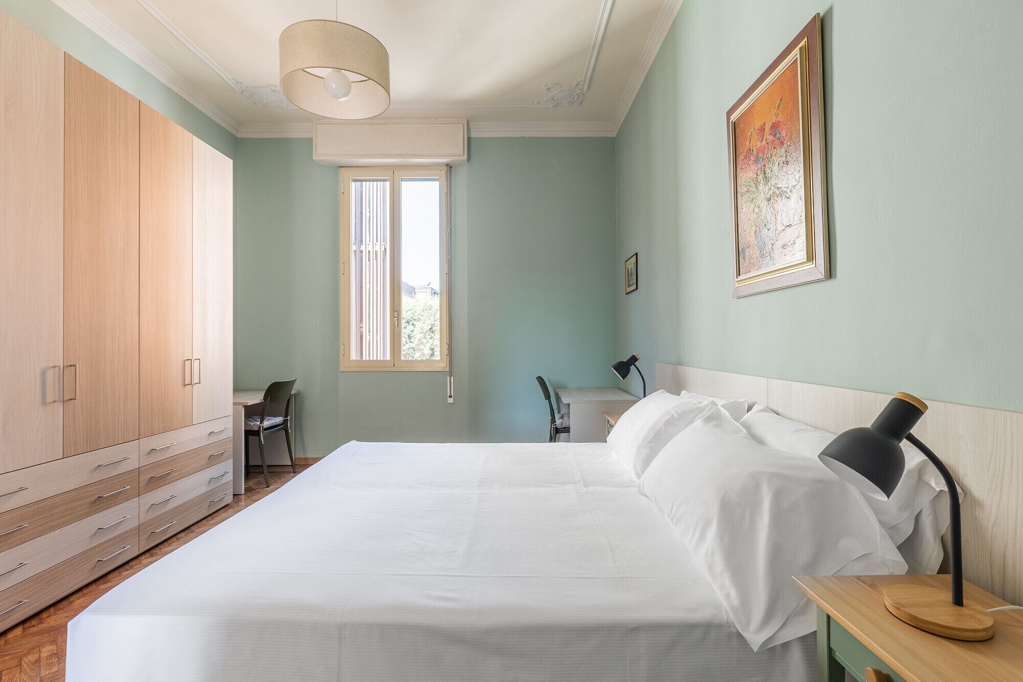 Un dormitorio con cama, escritorio, silla y armario.