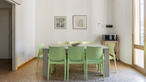 Ein Essbereich mit Tisch, Stühlen, Kunstwerken und einer Mikrowelle.