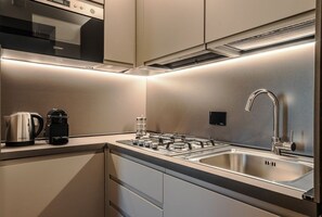A modern kitchen with stainless steel appliances, a built-in oven, and a double sink. - CS Spanish Steps Boutique A Apartment (Rome)
