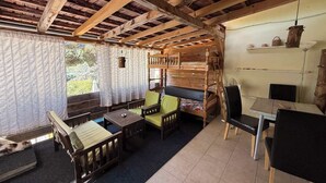 Ein rustikales Blockhaus mit einem hölzernen Doppelstockbett, einem Esstisch und einem Stuhl.