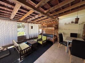 A rustic cabin interior with a wooden bunk bed, a dining table, and a chair. - Blue Horizon - Plavi horizonti (Bigova)