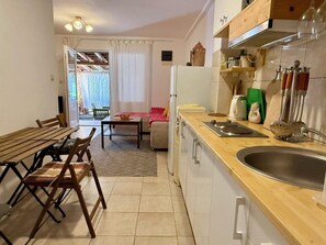 Una cocina compacta con encimera de madera, un fregadero y un comedor con mesa y sillas.