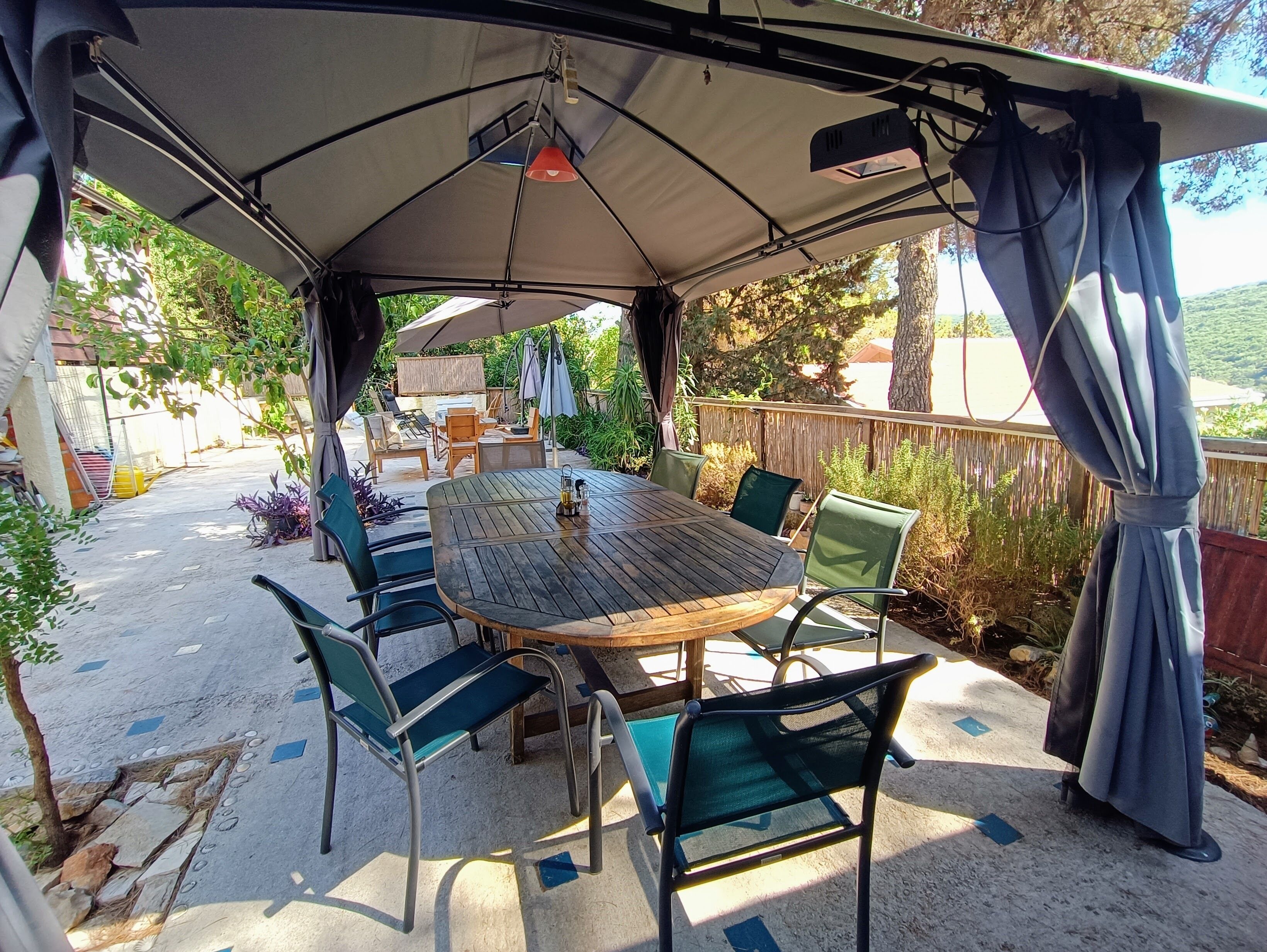 An outdoor patio with a table and chairs under a tent.