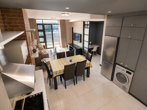 A modern kitchen with a dining area, built-in appliances, and a view through the window. - Luxury, safety and Convenience in the heart of Rosebank, Johannesburg!.. (Johannesburg)