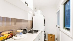 A compact kitchen with a sink, a refrigerator, and a window. - Genesta Ocean Sands Cowes (Cowes)