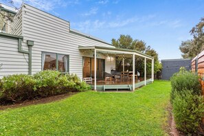 A house with a covered patio area, a lawn, and a garden. - Genesta Ocean Sands Cowes (Cowes)