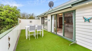 A small house with a green lawn, a satellite dish, and a butterfly decoration. - Genesta Ocean Sands Cowes (Cowes)