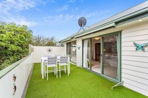 A small house with a green lawn, a satellite dish, and a butterfly decoration. - Genesta Ocean Sands Cowes (Cowes)