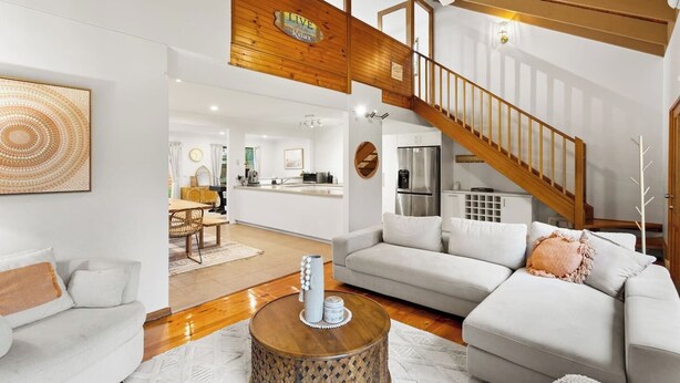 A modern living room with a sofa, coffee table, and a staircase leading to an upper level. - Genesta Ocean Sands Cowes (Cowes)