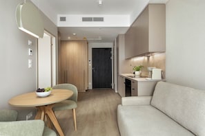 A compact living space with a dining area, kitchenette, and a sofa. - Olivia Pulse Gdańsk (Gdańsk)