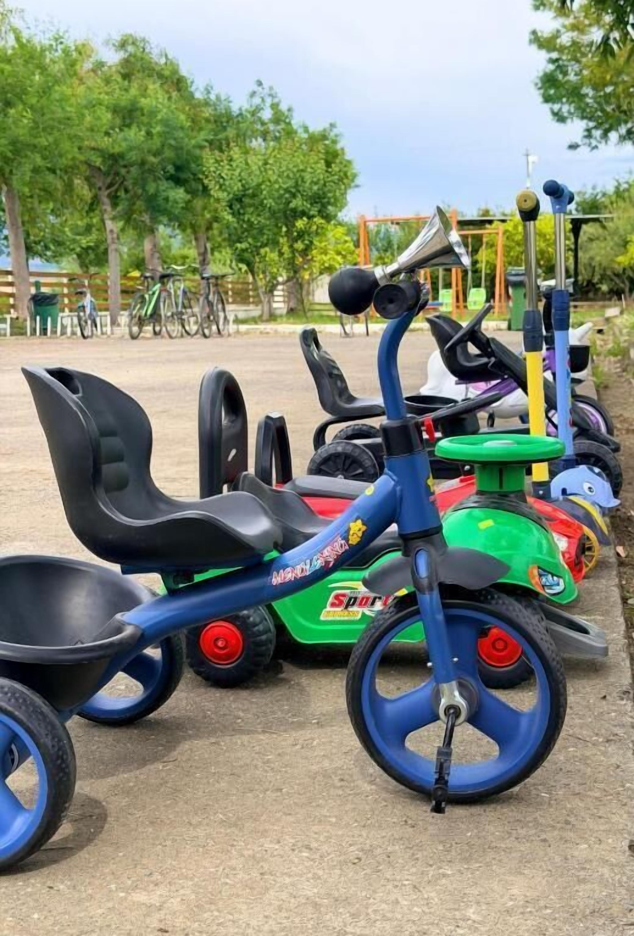 A row of children's tricycles parked outdoors.