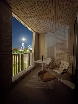 A balcony with a table and chairs, a bottle, and a wine glass. - The Royal Suite under the castle with river views & private parking (Bratislava-Staré Mesto)