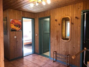 A wooden interior with a bed, a door, and a mirror. - Komfortabler Doppelbungalow mit Terrasse im Ferienpark Mirow (Mirow)