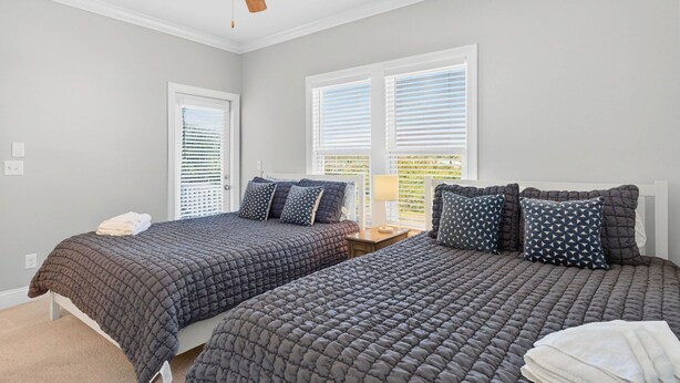 A bedroom with two beds, a ceiling fan, and a window with blinds. - Endless Summer, Oceanfront, 8 Bdrm, Pvt. Htd Pool, Pvt. Direct Beach Access (Holden Beach)