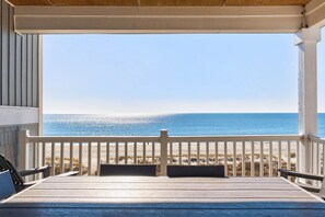 A covered outdoor seating area with a view of the beach. - Endless Summer, Oceanfront, 8 Bdrm, Pvt. Htd Pool, Pvt. Direct Beach Access (Holden Beach)