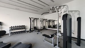Et fitnesscenter med løbebånd, styrkemaskiner og håndvægte.