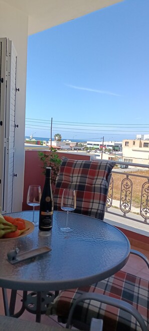 Ein Balkon mit Tisch, zwei Weingläsern und einer Flasche Riesling.