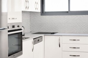 Una cocina moderna con horno empotrado, estufa y lavavajillas.