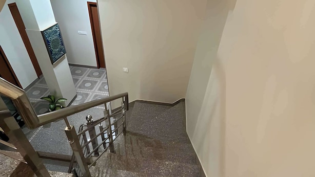 A staircase with a metal handrail leading to a landing.