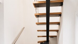 A spiral staircase with wooden steps and black metal railings. - Zidros Apartments Maisonette Apartment 4 (Sfakaki)