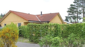 A two-story building with a red-tiled roof and a yellow facade. - Praktischer Doppelbungalow mit Terrasse im Ferienpark Mirow (Mirow)