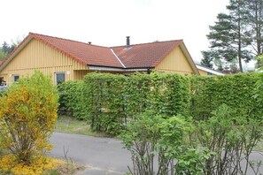 Ein zweistöckiges Gebäude mit rotem Ziegeldach und einer gelben Fassade.