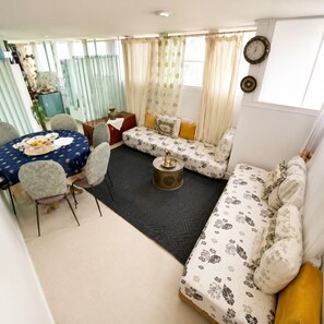 A living room with a round table, sofa, and chairs.
