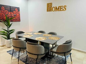 Un comedor con una mesa, sillas y una planta en maceta.