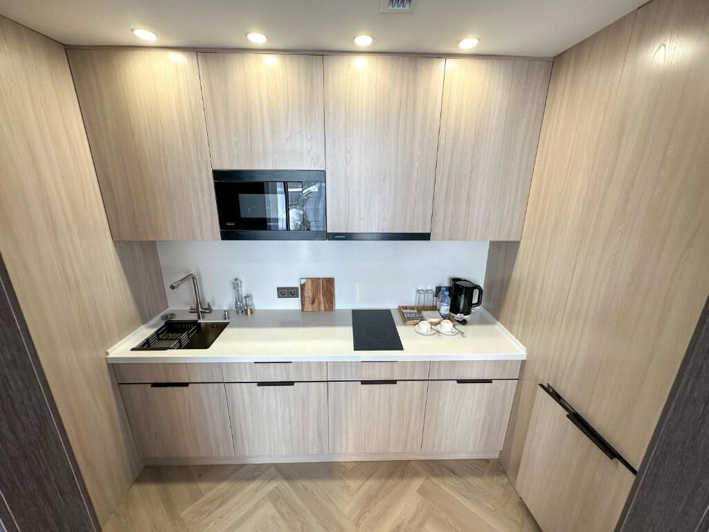 A compact kitchen with a built-in microwave, a sink, and a coffee maker.