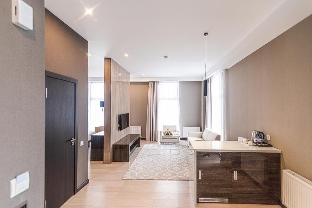 Una sala de estar moderna con un sofá, una mesa de centro y un televisor montado en la pared.