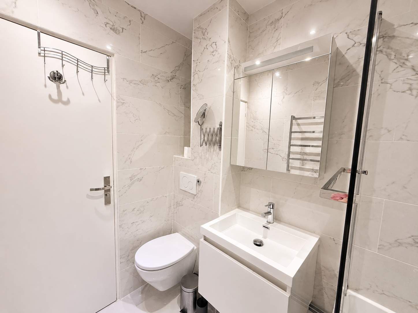 Une salle de bain moderne équipée de toilettes, d’un lavabo et d’un espace douche.