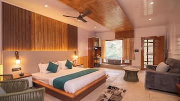 A bedroom with a large bed, a ceiling fan, and a view of the outdoors.
