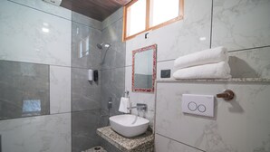 A bathroom with a marble floor, a white sink, a mirror with a red frame, and a towel rack.