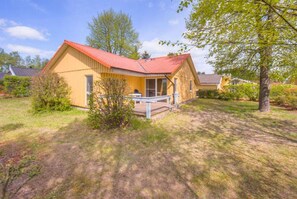 A single-story house with a red roof, a porch, and a small front yard. - Gemutlicher Doppelbungalow mit Garten und Terrasse im Ferienpark Mirow (Mirow)