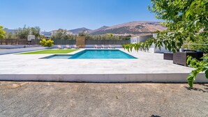 A swimming pool with lounge chairs, a concrete deck, and a view of hills. - Cubo's Maipa Rural House / Private pool / BBQ / Free Wi-Fi (Loja)