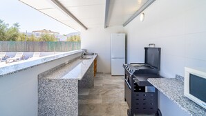 A compact kitchen with a built-in refrigerator, a sink, and a grill station. - Cubo's Maipa Rural House / Private pool / BBQ / Free Wi-Fi (Loja)