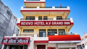 A multi-story hotel with a prominent red and white sign for Revivo Hotel A.V Grand Inn. - A.V Grand Hotel (Kanpur)