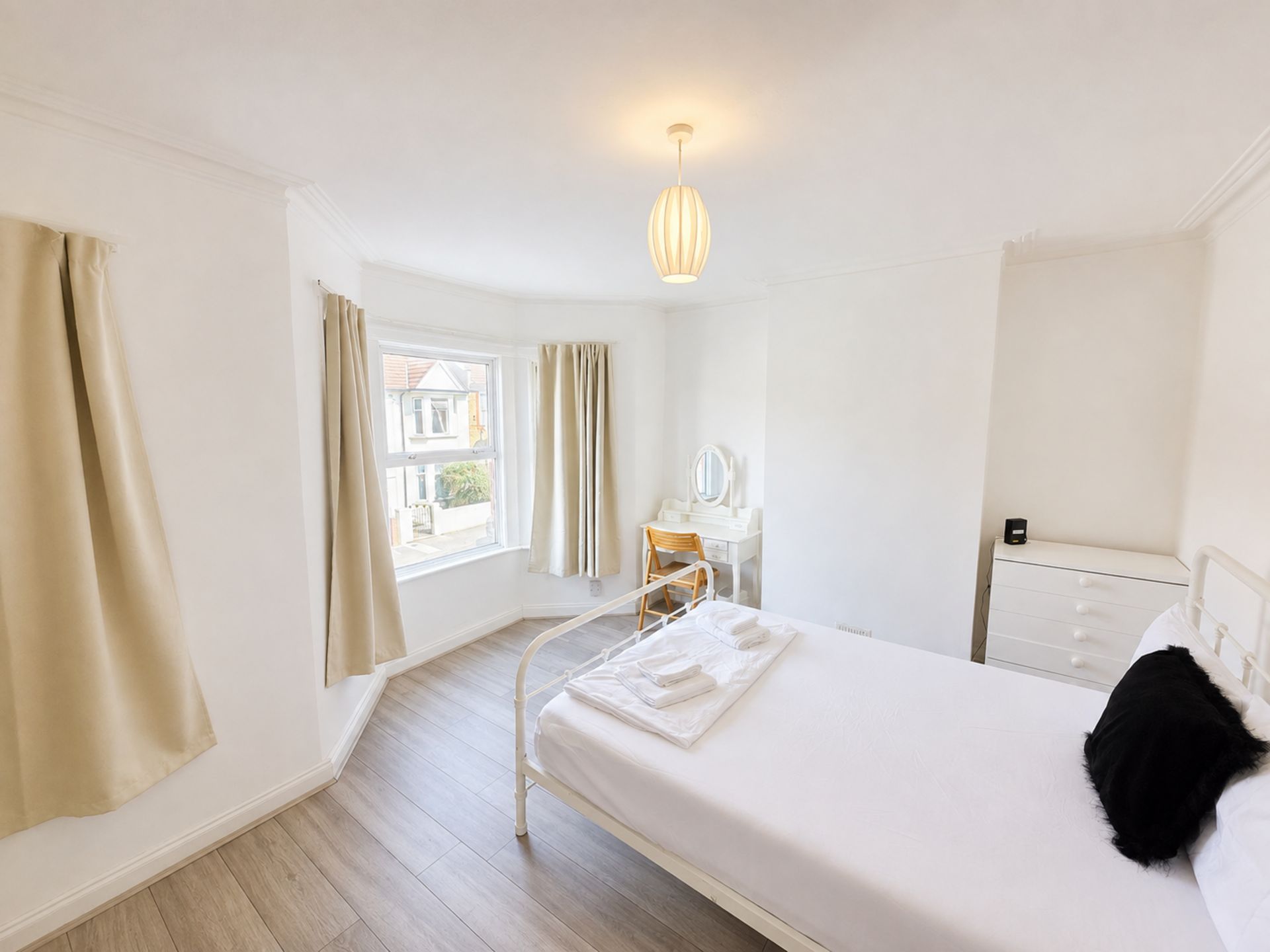 Ein Hotelzimmer mit einem Bett, einem Nachttisch und einem Fenster mit Vorhängen.