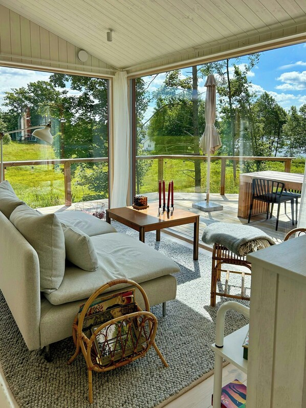 Una habitación soleada con un sofá, una mesita y una silla de mimbre.