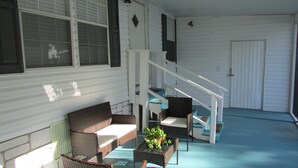 A covered porch with wicker furniture, a staircase, and a door. - 3 Bedroom Home, Lots of Room Pools, golf course, Fishing Pier and Private Beach. (Micco)