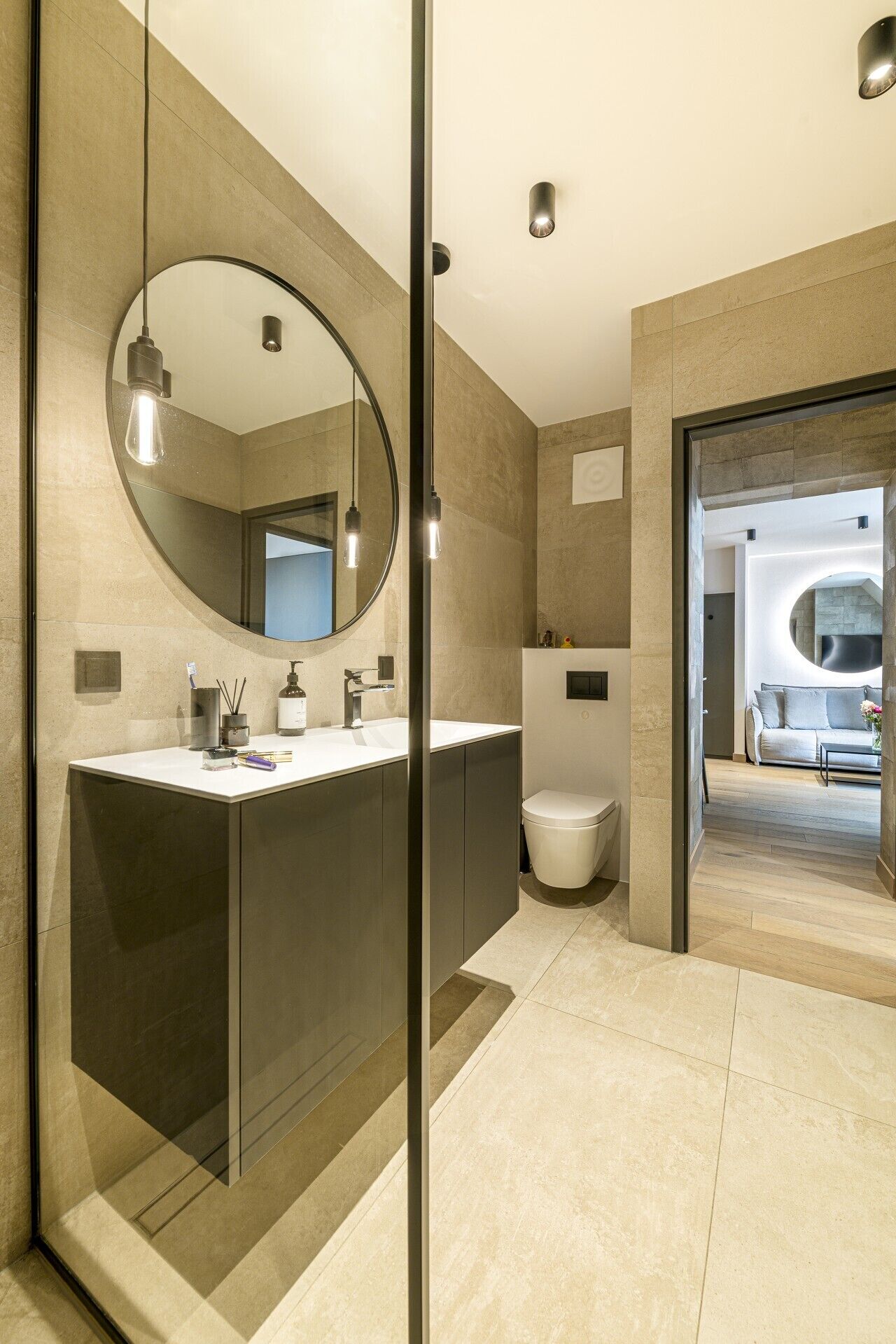 Une salle de bain moderne avec un grand miroir, un lavabo et des toilettes.