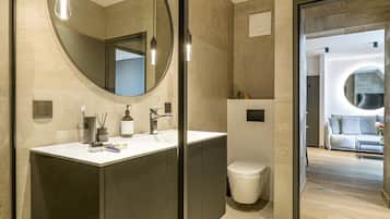 Une salle de bain moderne avec un grand miroir, un lavabo et des toilettes.